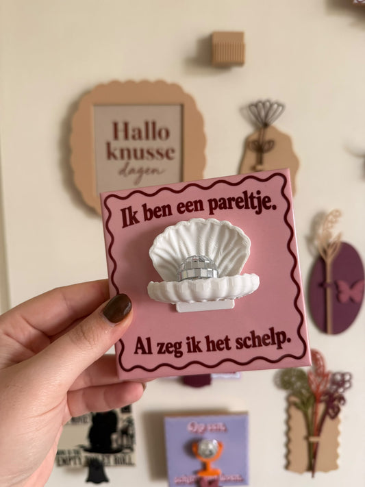 Roze tegel met tekst Ik ben een pareltje. Al zeg ik het schelp, witte schelp en spiegelende discobal