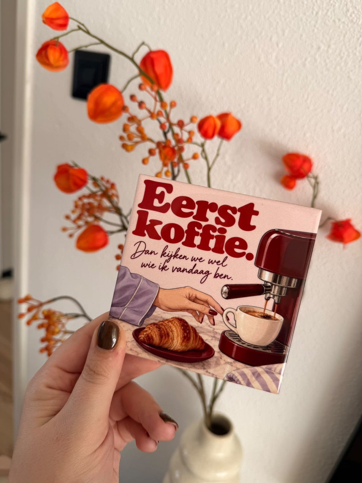 Hoogglans tegel met de tekst Eerst koffie en een espressomachine met croissant