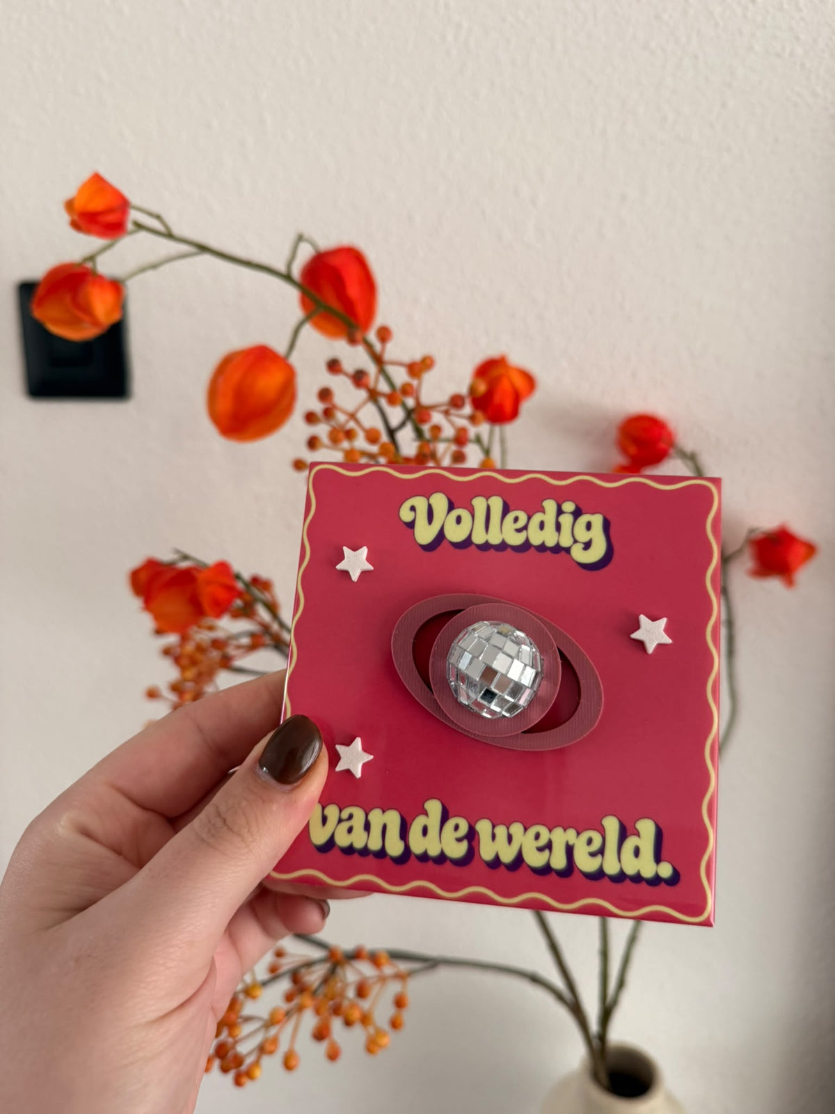 Roze-rode tegel met tekst Volledig van de wereld, sterren en planeet met spiegelende discobal